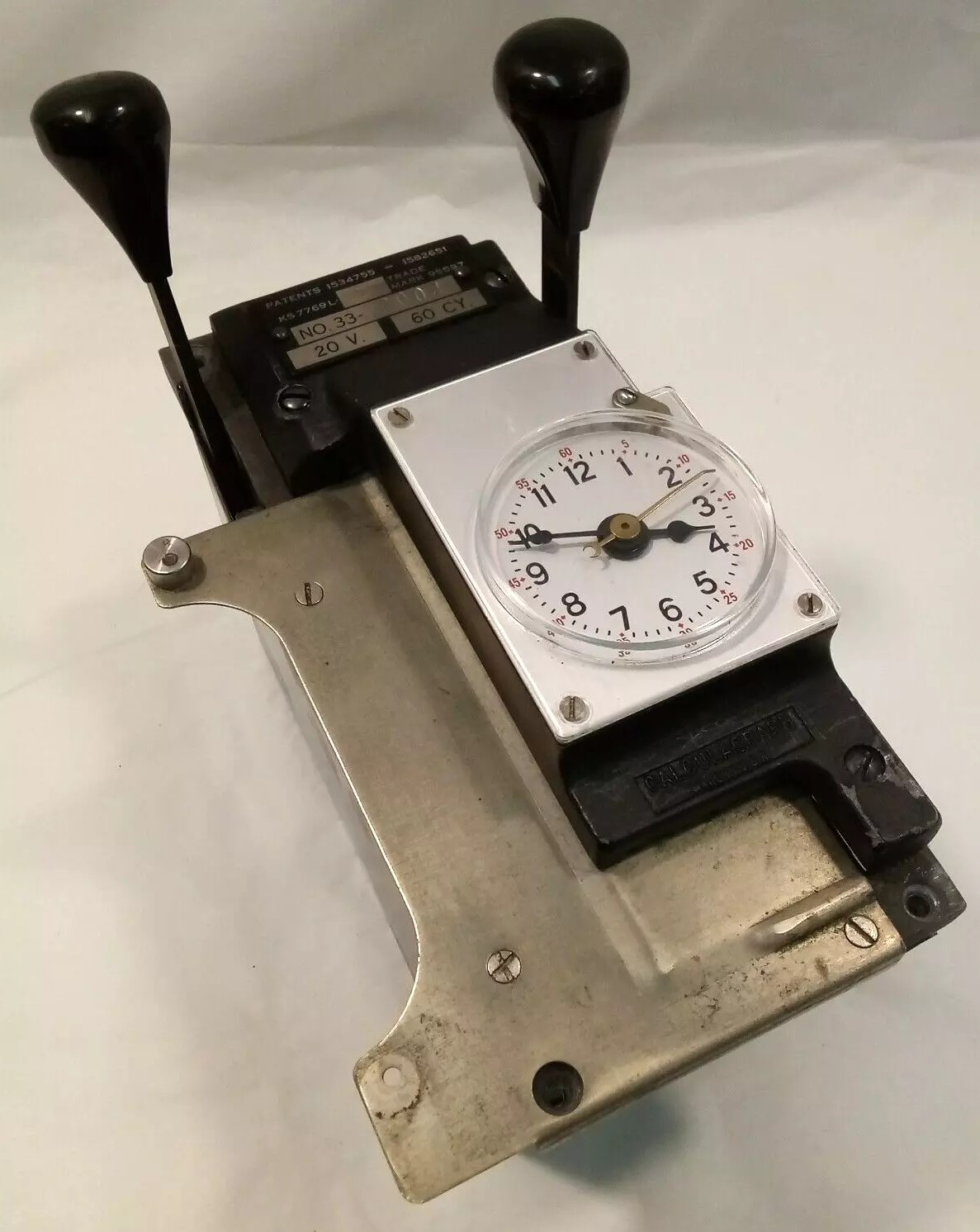 Metal machine with two handles and a dial, used to record call times.