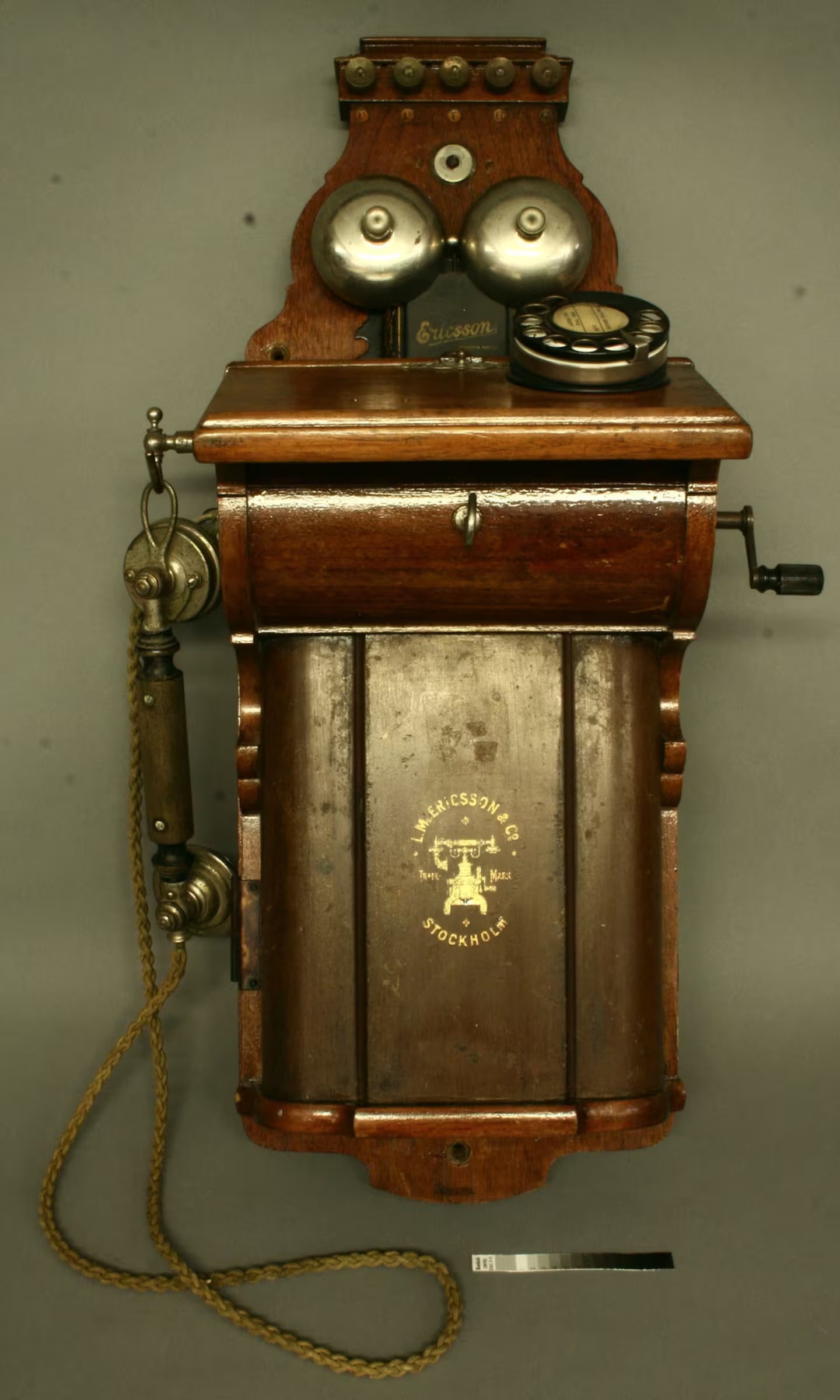 Large wooden and metal, wall-mounted telephone with a crank handle.